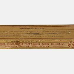 Rectangular, narrow, brown cardboard box with printing.