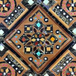 Detail of timber inlay jewellery box. Geometric patterns in dark and light light brown, blue, yellow, white and red.