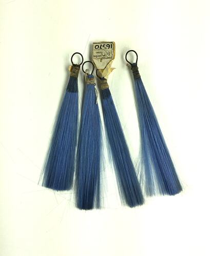Four blue tassels made from finely spun glass.