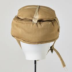 Beige cotton cap, padded, with strap. Back view.