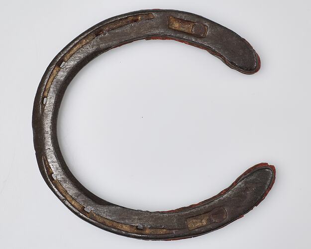 Handmade 'U' shaped metal horseshoe, with red rubber inserts.