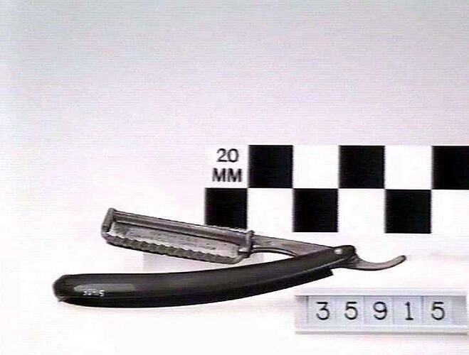 Safety razor with rotating blade retracting into curved handle.