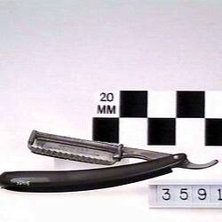 Safety razor with rotating blade retracting into curved handle.