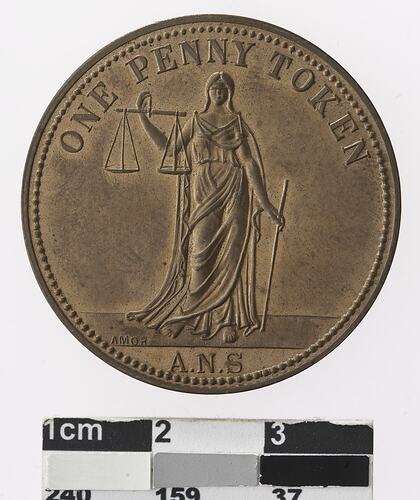 Round bronze coloured medal with woman holding scales and text surrounding.