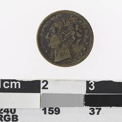 Round bronze coloured medal with profile of a woman and text surrounding.