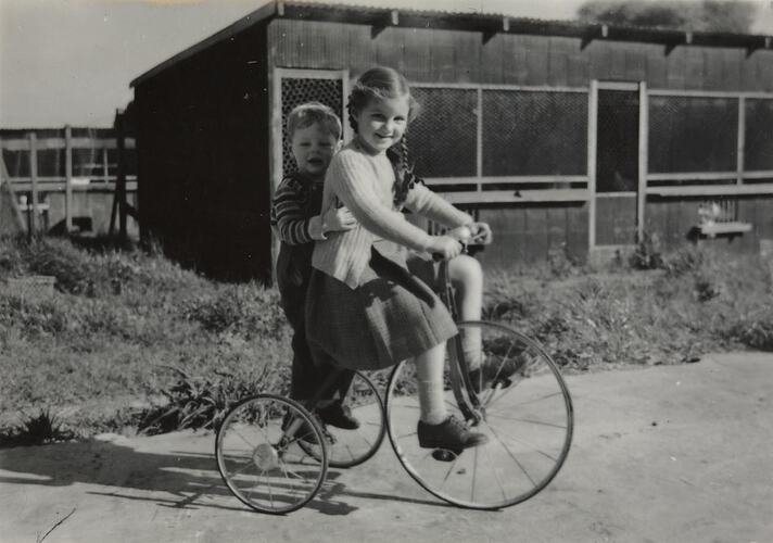 Digital Photograph - Boy & Girl Riding Tricycle in front of Henhouses, Springvale, 1950s