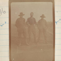 Three soldiers, man on left and right wearing slouch hats.