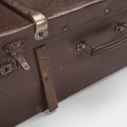 Brown hard leather suitcase detail. Rusted metal lock and leather handle.