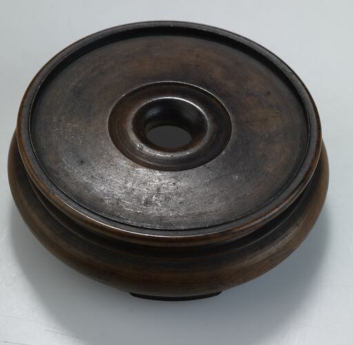 Round wooden stand. Central circular groove.