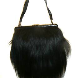Black fur handbag, suspended.