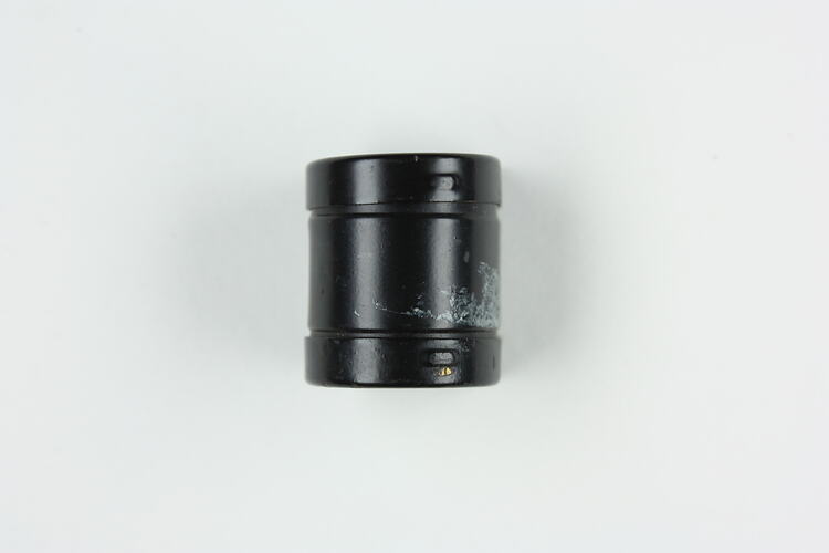 Small, cylindrical, black film cartridge.