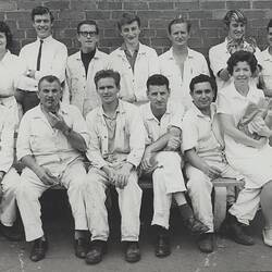 Casual group portrait of workers in factory uniform.