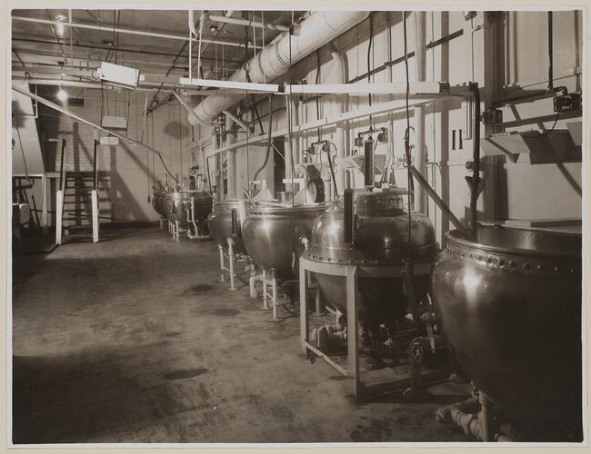 Industrial interior, dominated by six large round vats.