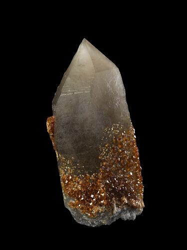 Small orange crystals on larger white prismatic crystal.