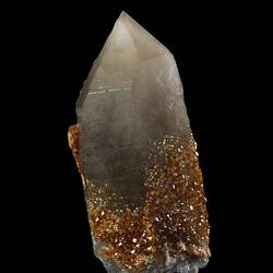 Small orange crystals on larger white prismatic crystal.