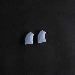 Two light blue plastic, trapezoid, facetted devices.