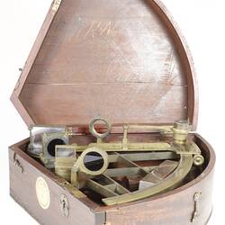 Wedge shaped wooden box, open with instrument inside.