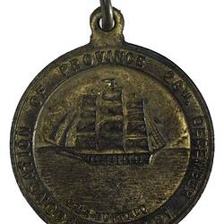 Round medal, lettering around. At centre sailing ship at sea. Suspension loop at top.