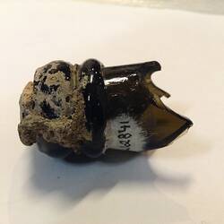 Top section of green bottle that includes the cork, finish and wire.