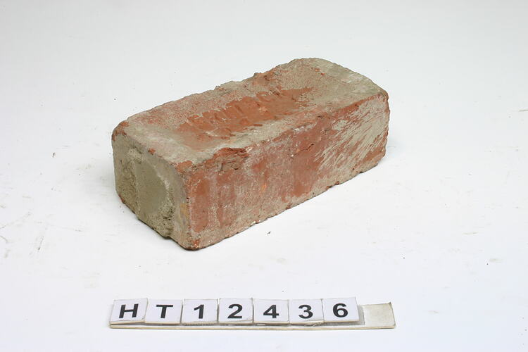 Red, machine pressed brick with a frog on one side.