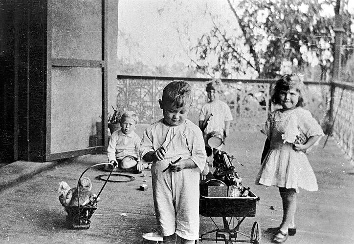 [Children playing with toy trains, circa 1925.]