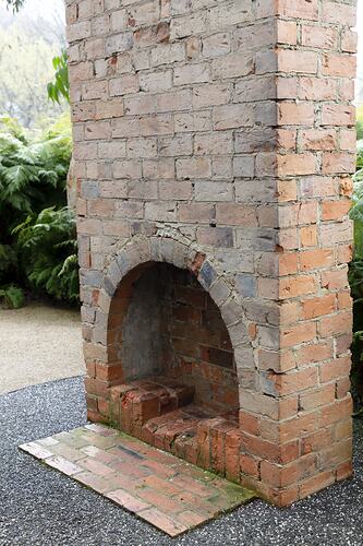 Red brick chimney with arched fireplace. Front and side of hearth.