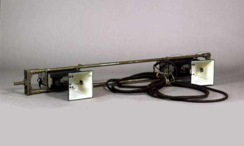 Metal frame with 2 square sockets and cord.