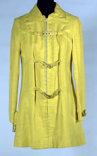 Yellow mini coat dress with tabs and zipper.
