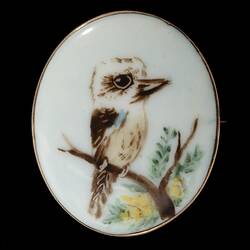 White porcelain brooch with painted kookaburra.