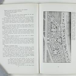 Open booklet with white pages and black printing. Aerial view of street plan.