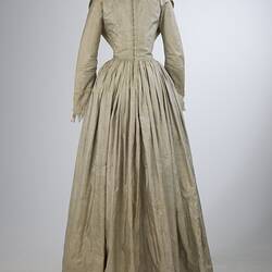 Pale grey striped silk dress with long sleeves and long skirt. Back view.