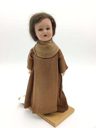 A doll dressed as a friar in brown robes