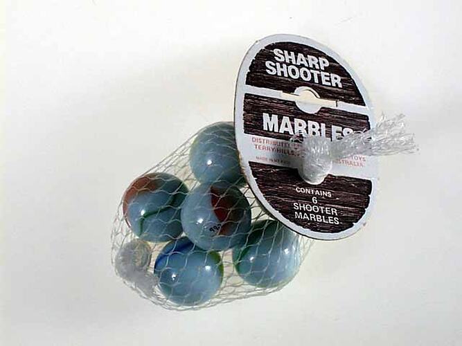 Marbles in plastic mesh bag with label.