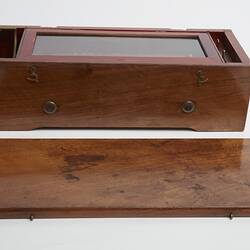 Wooden rectangular box with separate wooden lid. Glass section on top on box.