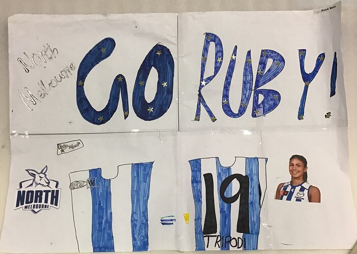 White paper handmade banner with blue writing. Small picture of female footballer.