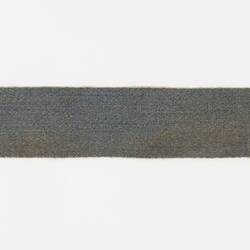 Girth strap is blue hessian with dirty white elastic and leather at join of materials and near buckles.