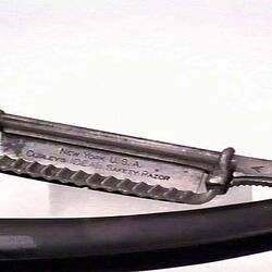 Detail of words inscribed on blade of safety razor