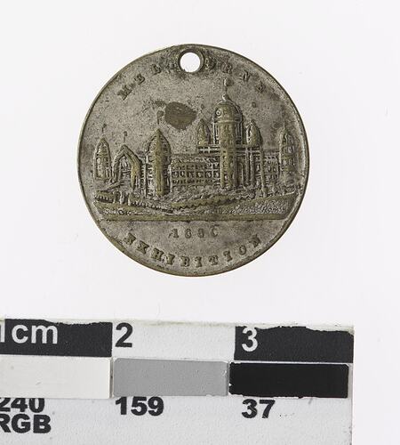 Round medal with building, text above and below.