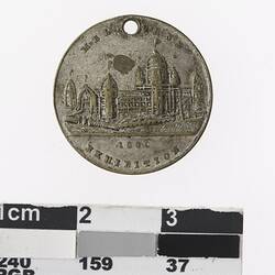 Round medal with building, text above and below.