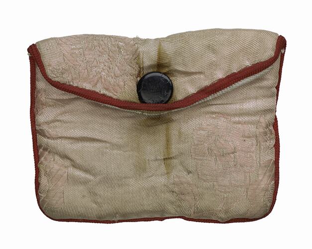 Pale pink silk envelope-style pouch with red trim and black button.