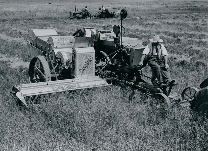 Man operating a header in a field.