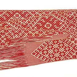 Woven belt with red and white geometric patterns.