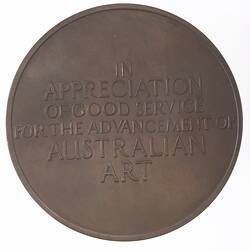 Round bronze medal with raised text.