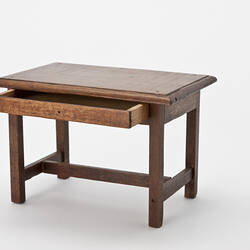 Rectangular wooden table with open drawer.
