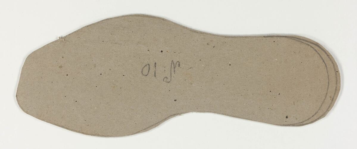 A cardboard pattern for a child's shoe sole.