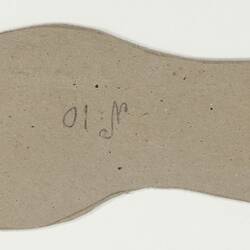 A cardboard pattern for a child's shoe sole.