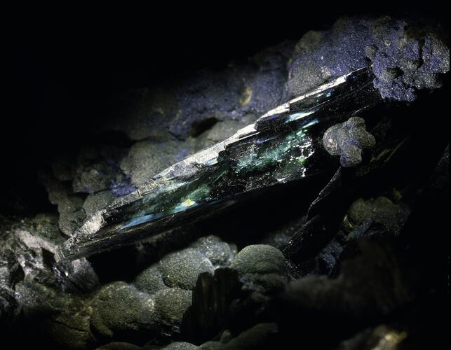 Green-blue iridescent mineral shaft.