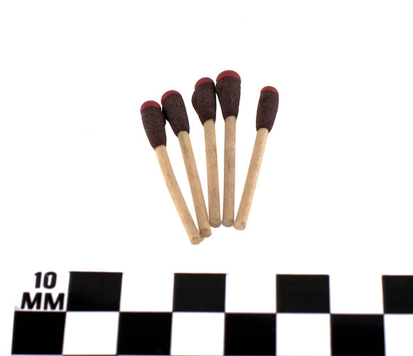 Five off-white wooden matches with red tips.