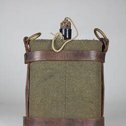 Green fabric water bottle holder with brown leather straps.