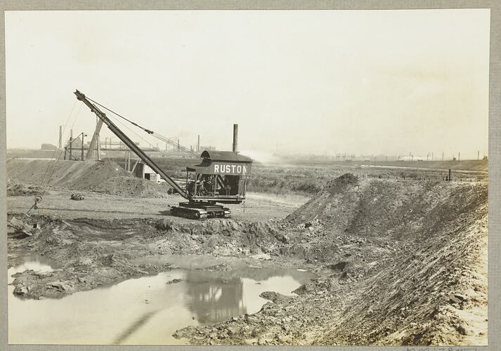Monochrome photograph of a grab excavator.